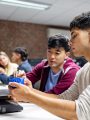 International students working with 3D printer in classroom setting.