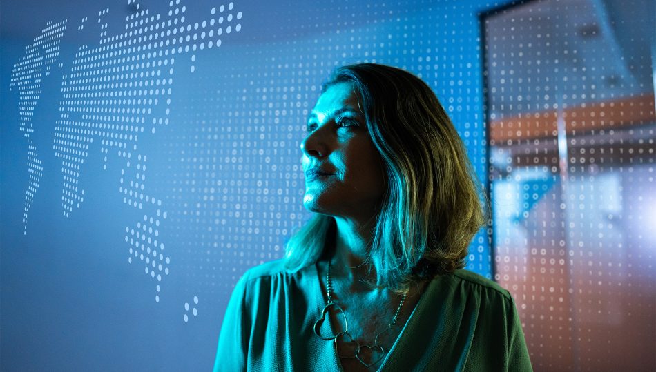 Woman looking up at screens looking optimistic about technology.