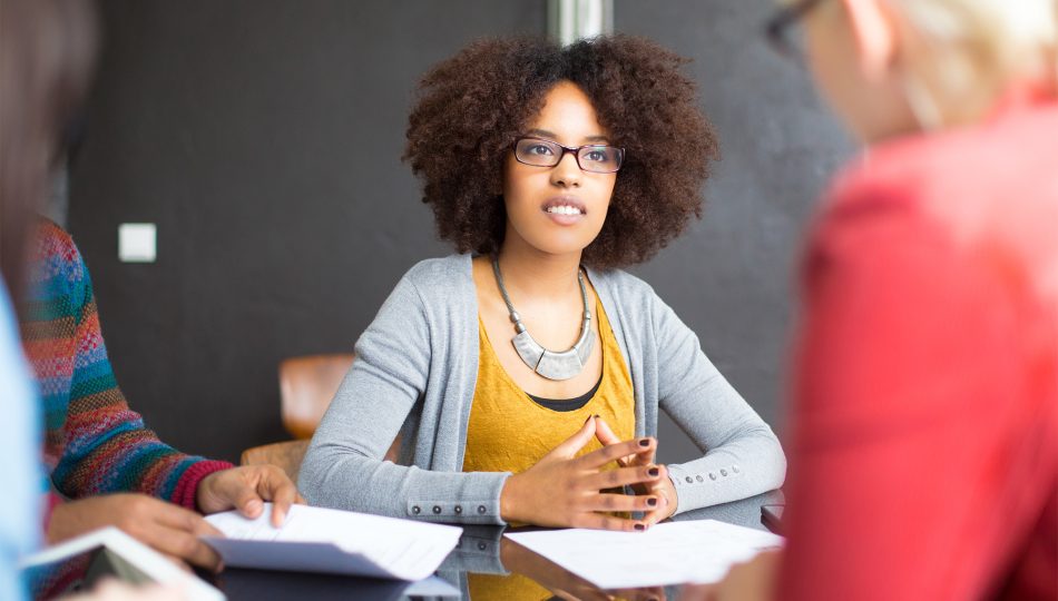 Woman sitting at board table during training.